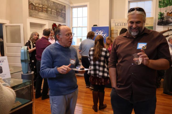 A picture of Drs. Robin Cooper and Jeramiah Smith chatting with additional people in the background.