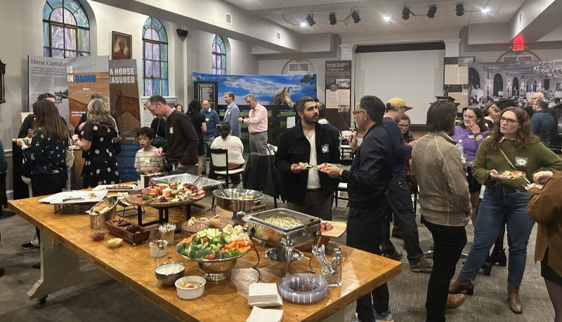 A large group picture of attendees chatting.