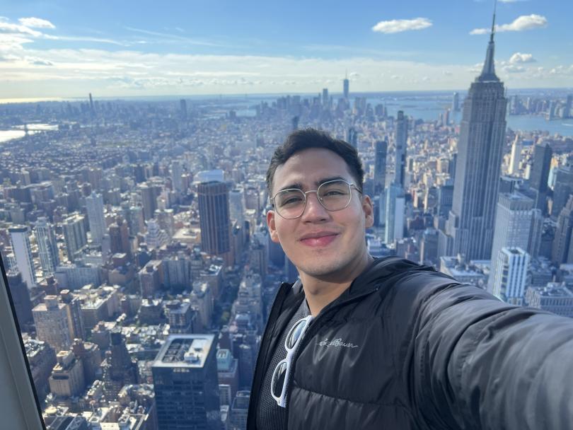 A picture of Emilio Oviedo Rivadeneira standing in front of a city view background.