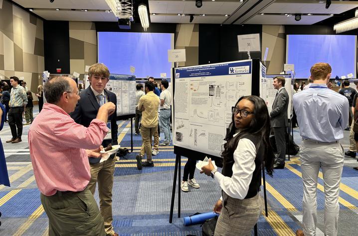 Professor Robin Cooper with students at the 2024 Showcase of Undergraduate Scholars.