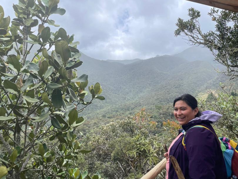 Dr. Zenil-Ferguson standing outside in a tropical forest area smiling. 
